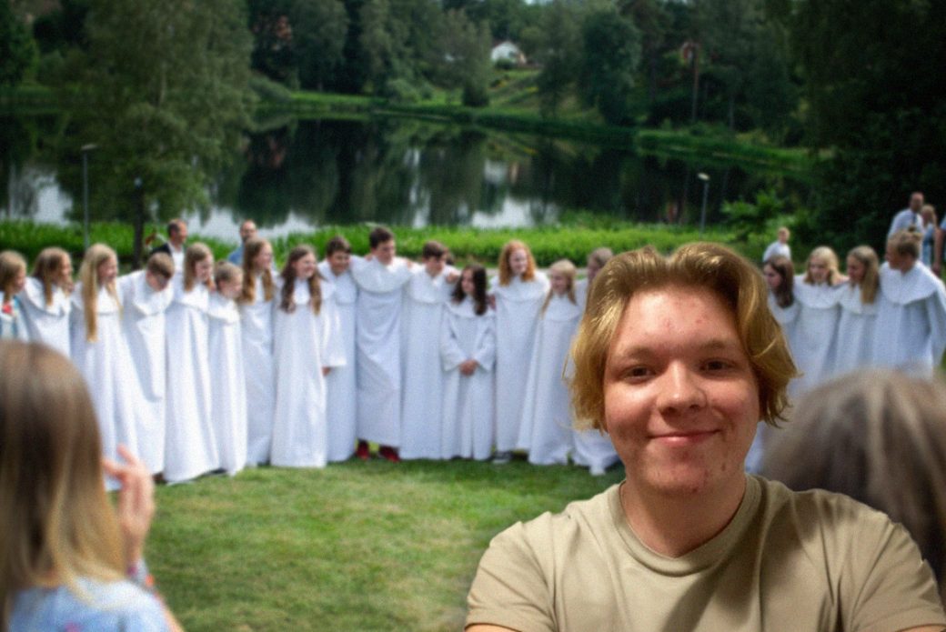 Foto p&aring; Hannes. I bakgrunden syns konfirmander i vita k&aring;por.