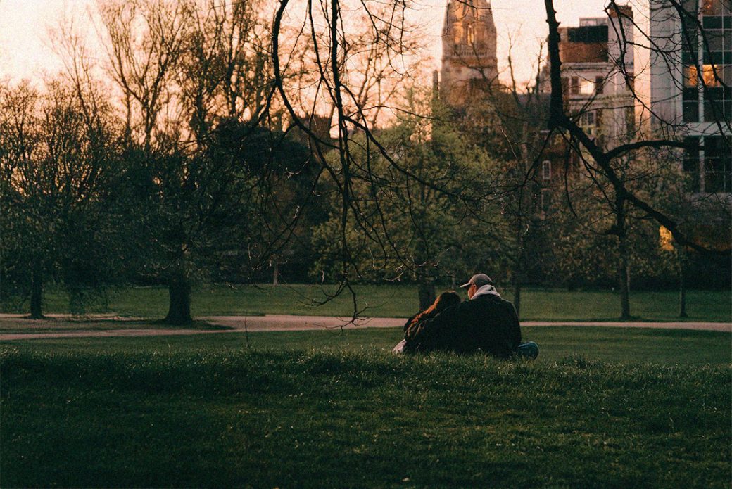 Par sitter tillsammans i solnedgången.